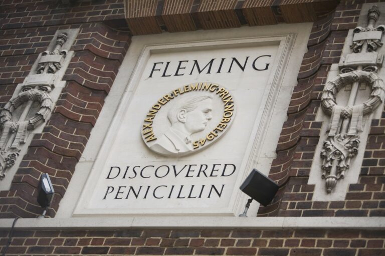 Image of sign outside hospital building saying 'Fleming discovered penicillin' with an image of Sir Alexander Fleming's face in profile.