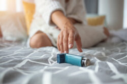 Woman's hand reaching towards inhaler