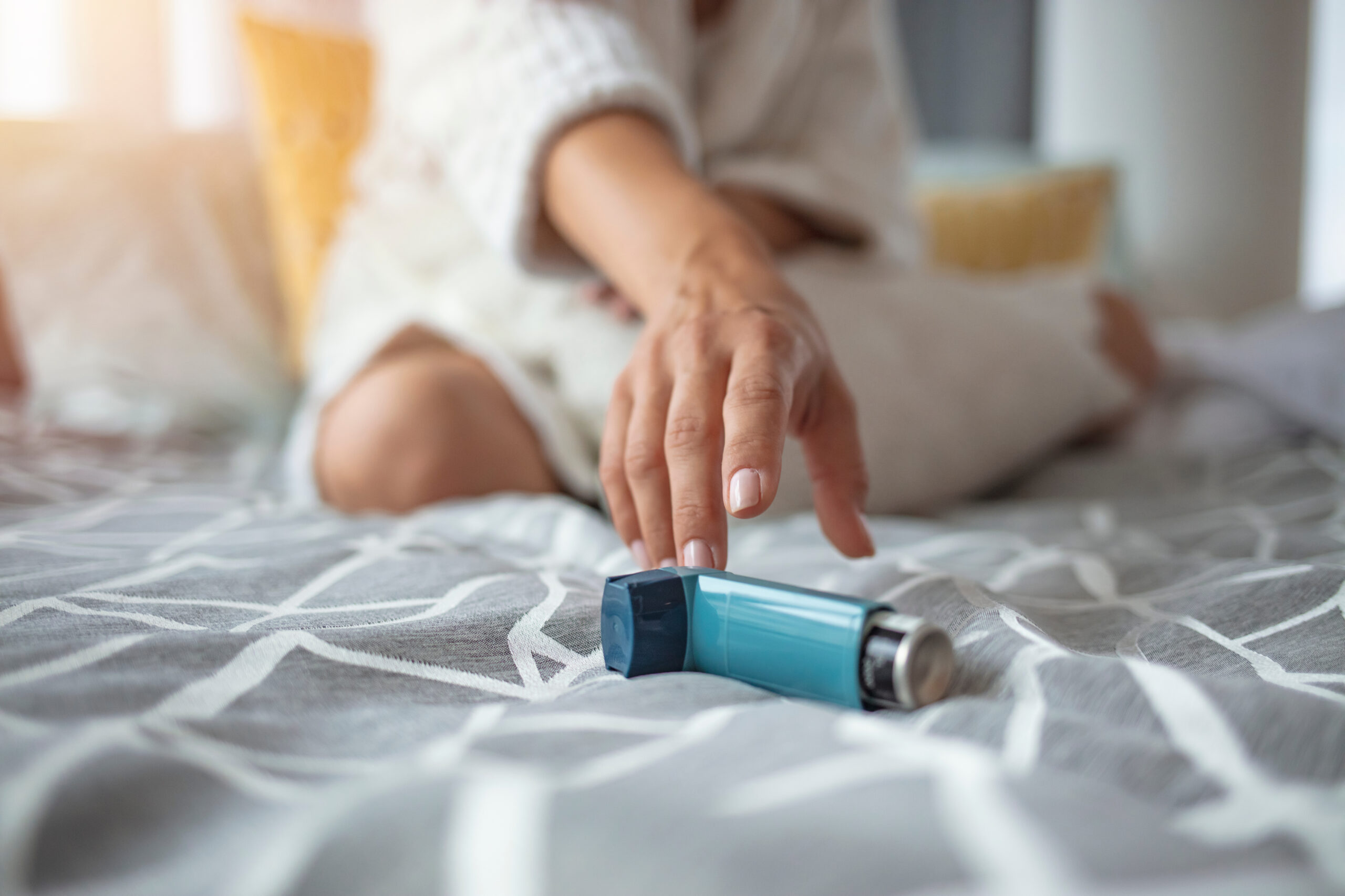 Woman's hand reaching towards inhaler